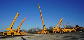 A yard lineup of Broderson IC-200 carry deck cranes staged for pick-and-carry work.