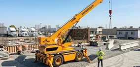 Broderson IC-280 Carry Deck Crane set up on outriggers for controlled precast placement.