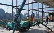 Maeda MC285C mini spider crane operating indoors on a high-rise construction floor