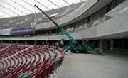 Maeda MC405C spider crane operating inside a stadium seating area during construction work