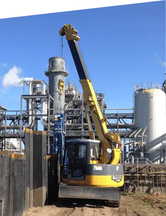 Mini crawler crane performing lifting work at an industrial facility