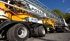 Potain Hup M 28-22 A self-erecting crane on the road, folded for safe transport to the jobsite.