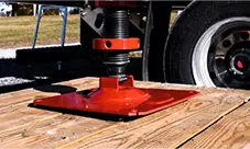 Potain Igo MA 21 outrigger foot set on timber mats for stable, level setup and lifting.